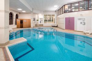 a large pool with blue water in a building at Crowne Plaza Solihull, an IHG Hotel in Solihull