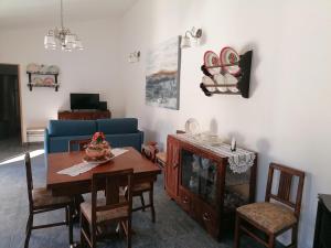 ein Wohnzimmer mit einem Tisch und einem blauen Sofa in der Unterkunft Casas de Marvão - Quinta da Bela Vista in Marvão