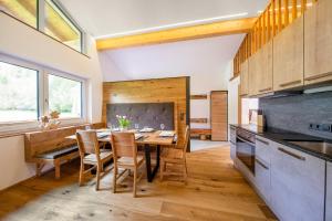 a kitchen with a wooden table and chairs in a room at Bergblick Apartment in Wald im Pinzgau