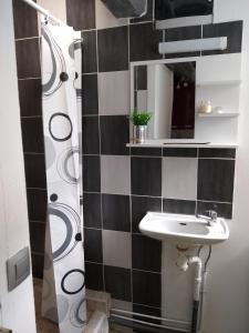 a black and white bathroom with a sink and a shower at Bienvenue au Relais des Meilles in Caudebec-en-Caux