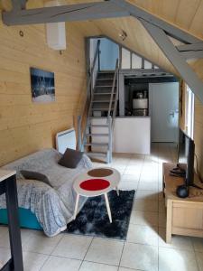 ein Schlafzimmer mit einem Bett, einem Tisch und einer Treppe in der Unterkunft Bienvenue au Relais des Meilles in Caudebec-en-Caux