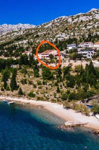 una vista aérea de una playa con un círculo naranja en Apartments Amari, en Starigrad-Paklenica