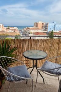 een tafel en stoelen op een balkon met uitzicht op de oceaan bij Family-Appartment in Santa Pola