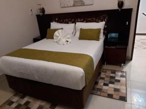 Un dormitorio con una cama grande con una flor. en Top Stay Inn en Kasane