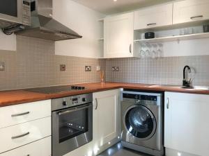 a kitchen with a washer and a washing machine at Perfect for Families & Business - Demha Nights in Birmingham