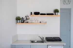 a kitchen with a sink and a counter top at K & G Central Apartments Fira in Fira