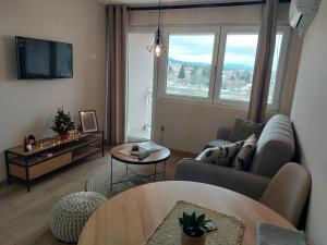un soggiorno con divano e tavolo di M Apartments a Soko Banja