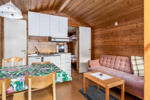 a room with a bed and a couch and a table at Hyttgårdens fjällstugor i Huså, Åre kommun in Huså