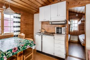 eine Küche mit weißen Schränken und einem Tisch in einer Hütte in der Unterkunft Hyttgårdens stugby i Huså, Åre kommun in Huså