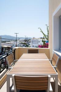 a wooden table and chairs on a balcony at K & G Central Apartments Fira in Fira