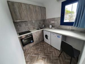 eine Küche mit einer Waschmaschine, einem Trockner und einem Fenster in der Unterkunft EDEM HOUSE FINIKAS in Loutro