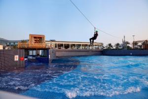 a man flying through the air while riding a surfboard at Radisson Blu Hotel & Resort, Abu Dhabi Corniche in Abu Dhabi