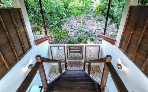 una escalera que conduce a una casa con ventanas grandes en Blue Planet Dive Resort en Bira