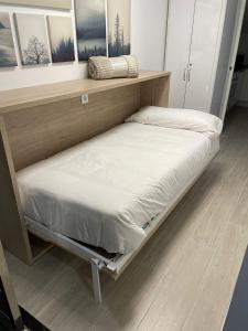 een bed op een plank in een kamer bij Ático Plaza Mercado 4,5 in Salamanca