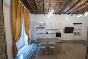 a kitchen with a table and chairs in a room at Casta Diva Luxury Apartments -Self check-in in Palermo