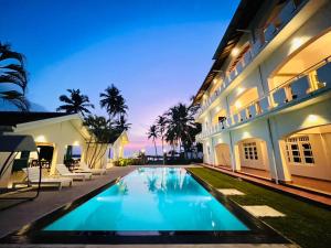 a swimming pool in front of a building at Shangrela Beach Resort by ARK in Ambalangoda