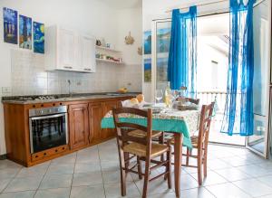a kitchen with a table with chairs and a stove at Lungomare Bay, e sei in spiaggia... in Cala Gonone