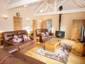 a living room with leather furniture and a fireplace at Pilots Loft in Menai Bridge