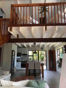 a living room with a staircase and a kitchen at Loft on Honey in Sunridge Park