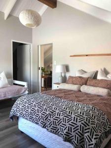 1 dormitorio con 1 cama con edredón blanco y negro en Loft on Honey en Sunridge Park