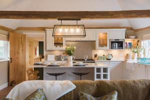 a living room with a couch and a kitchen at Cart Lodge by Bloom Stays in Groombridge