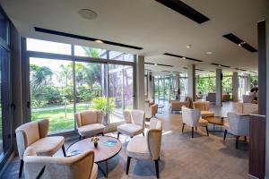 a waiting room with chairs and tables and windows at Panafrica Hotel Boutique & Spa in Bata