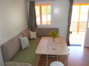 迪斯諾的住宿－Mobile home Sea Jezera Village, otok Murter，客厅配有一张沙发和一张桌子