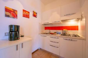 a kitchen with white cabinets and a coffee maker at Appartamenti Secrel in Tremosine Sul Garda +114 photos