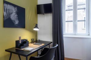a room with a desk with a zebra picture on the wall at Appartamento Nuovissimo Per 4 Ospiti + Wi-Fi in Trieste