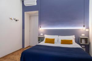 a blue bedroom with a bed with two yellow pillows at Appartamento Nuovissimo Per 4 Ospiti + Wi-Fi in Trieste