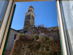 een raam met uitzicht op een klokkentoren bij Appartamenti Sant Andrea in Levanto