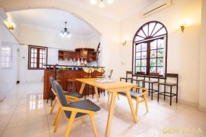 een keuken en eetkamer met een tafel en stoelen bij GEM VILLA 10 - 5 Bedroom, 6 Bathroom, Big Pool, Big Garden in Ho Chi Minh-stad