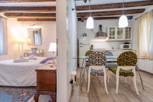 a kitchen and a bedroom with a table and chairs at San Marco New Romantic in Venice