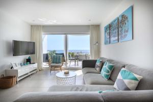 ein Wohnzimmer mit einem Sofa und einem TV in der Unterkunft Waterside 3 Bedroom Sea view in Luz