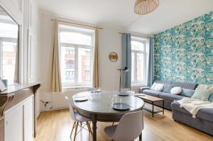 a living room with a table and a couch at NOCNOC - Le jardin du prefet in Lille