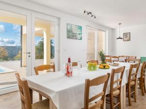 une salle à manger avec une table et des chaises blanches dans l'établissement Villa Valente with Pool, à Labin