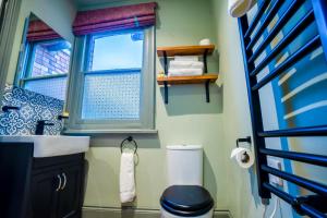 a bathroom with a toilet and a sink and a window at The Crown Hotel in Glastonbury