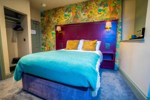 a bedroom with a large bed with a colorful headboard at The Crown Hotel in Glastonbury