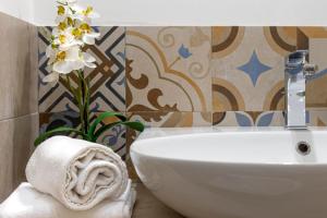 ein Bad mit einem WC, einem Waschbecken und Blumen in der Unterkunft Brand new guest room with Wi-Fi in the city center in Triest