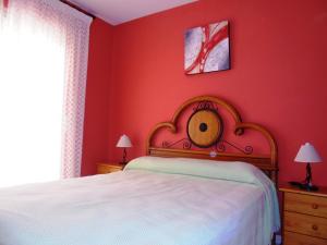 ein Schlafzimmer mit einem Bett und einer roten Wand in der Unterkunft Europeñiscola Holidays LEK in Benicarló + 23 Fotos