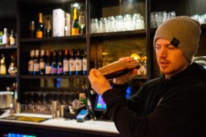 a man standing at a bar drinking from a bottle at The Crown Hotel in Glastonbury