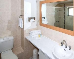 a bathroom with a toilet, sink and mirror at Comfort Inn Grammar View in Toowoomba