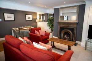 a living room with red furniture and a fireplace at The Helaina Apartments in Scarborough