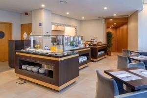 a restaurant with a counter with food on it at TRYP by Wyndham Porto Centro Hotel in Porto