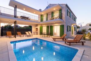 a house with a swimming pool in front of a house at Corte villas & apartments - AE1043 in Privlaka