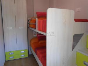 een slaapkamer met 2 stapelbedden en rode dekens bij I-Apartamento cerca de la Playa in Peñíscola