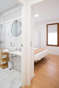 W białej łazience znajduje się umywalka i lustro. w obiekcie Apartamento Rural New Folch II w mieście Morella