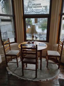 uma sala de jantar com uma mesa e cadeiras e uma janela em All Seasons Guesthouse em Douglas