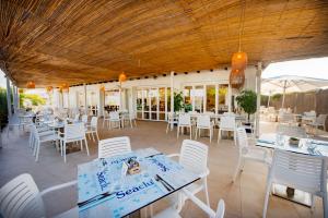 a restaurant with white tables and white chairs at Seaclub Alcudia in Port d'Alcudia