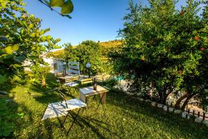 un patio con 2 sillas, una mesa y un árbol en Ceretanum Holiday House, en Giarratana